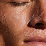 Close-up of a person's face with soap bubbles on skin