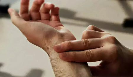 Hand resting on a wrist, taking a pulse to measure heart rate before sleep.