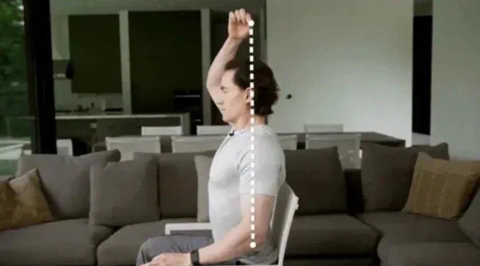 Bryan Johnson seated on a couch with a vertical posture line measurement extended above his head.