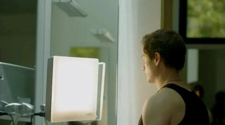 Bryan Johnson sitting in front of a 10,000 lux light therapy device for morning circadian rhythm support.