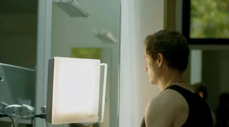 Bryan Johnson sitting in front of a 10,000 lux light therapy device for morning circadian rhythm support.