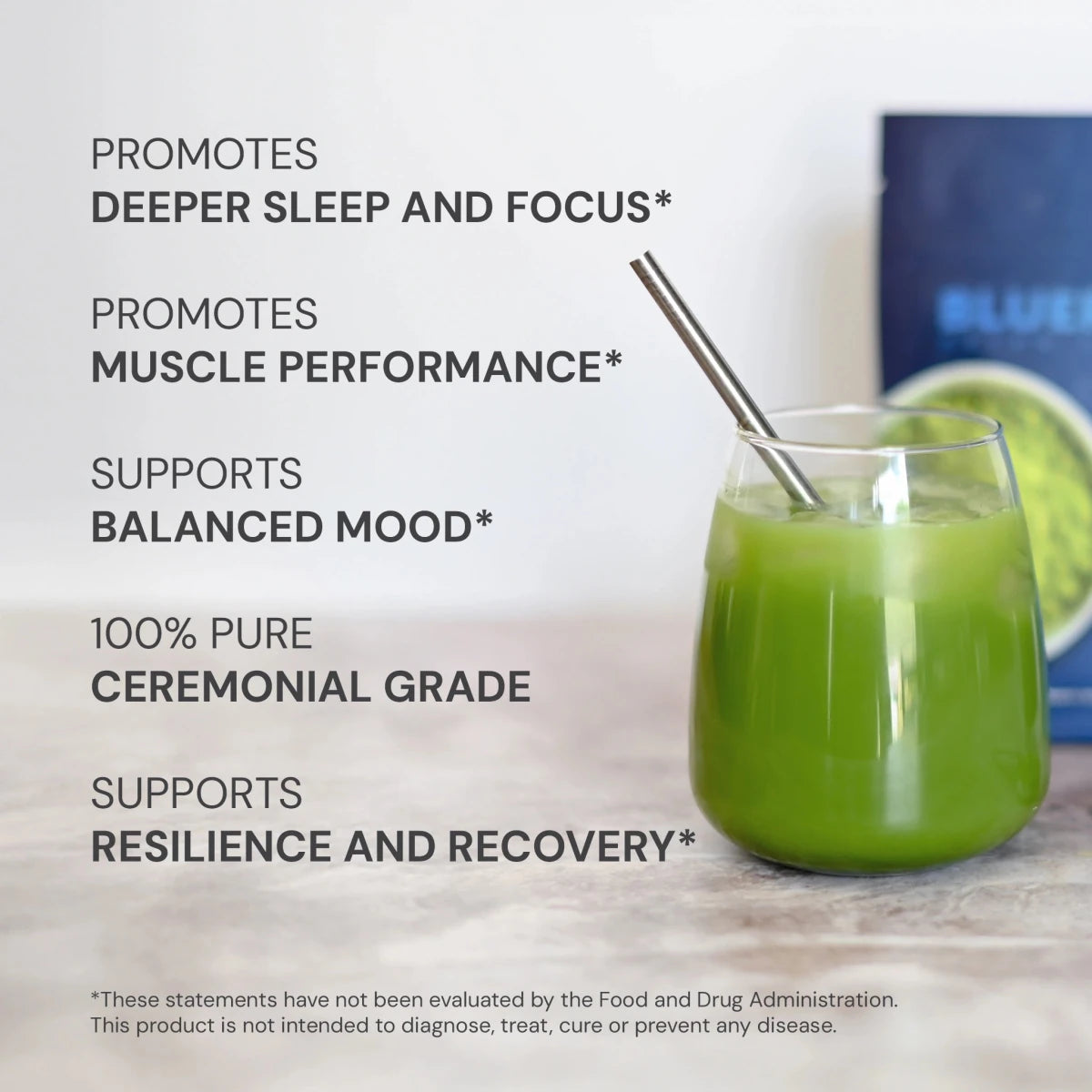 Glass of green liquid with a metal straw on a wooden surface, with text about product benefits.