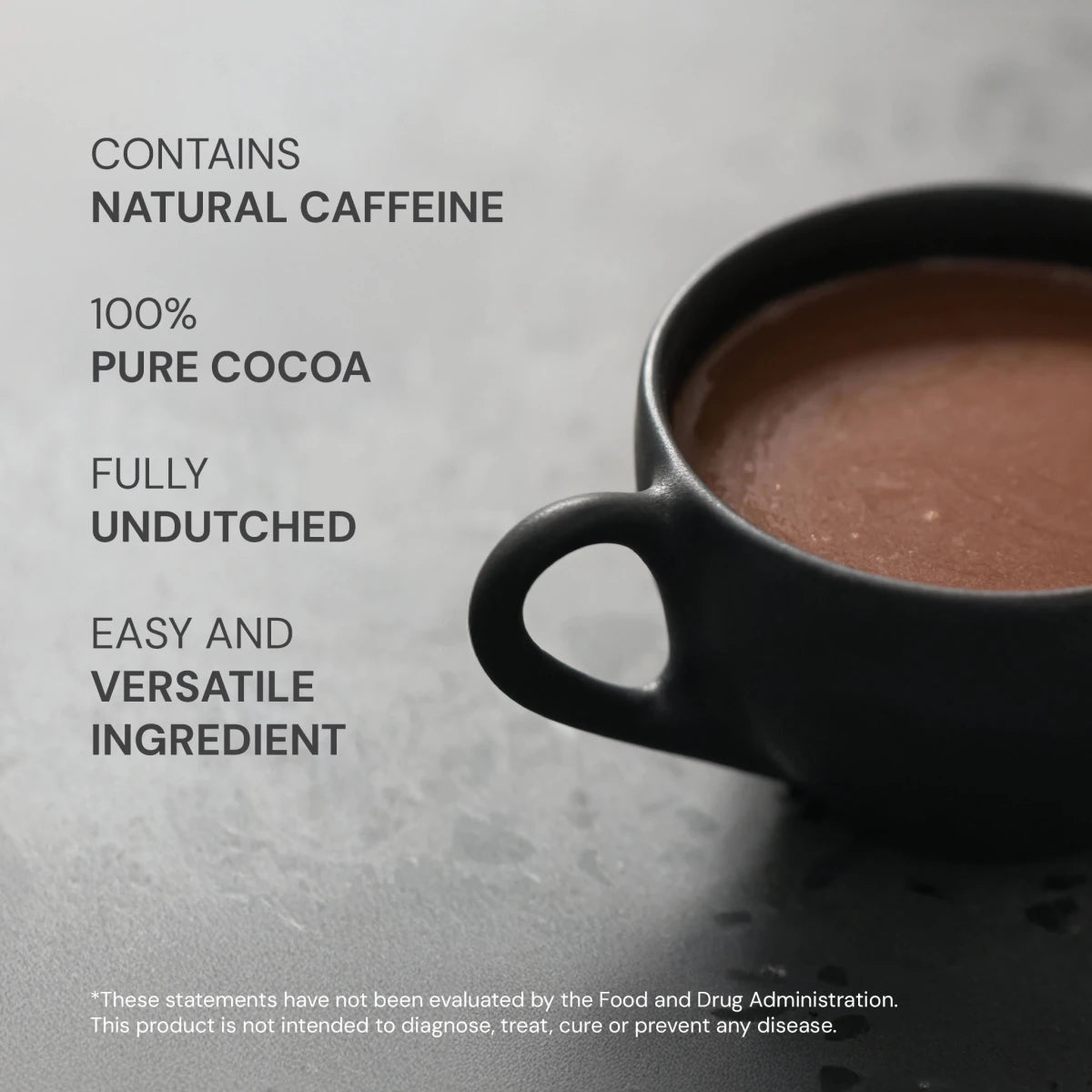 Black mug of hot chocolate with text about ingredients on a gray background