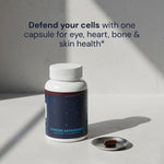 Blueprint Advanced Antioxidants supplement bottle and capsule on a stone surface — longevity cellular health support