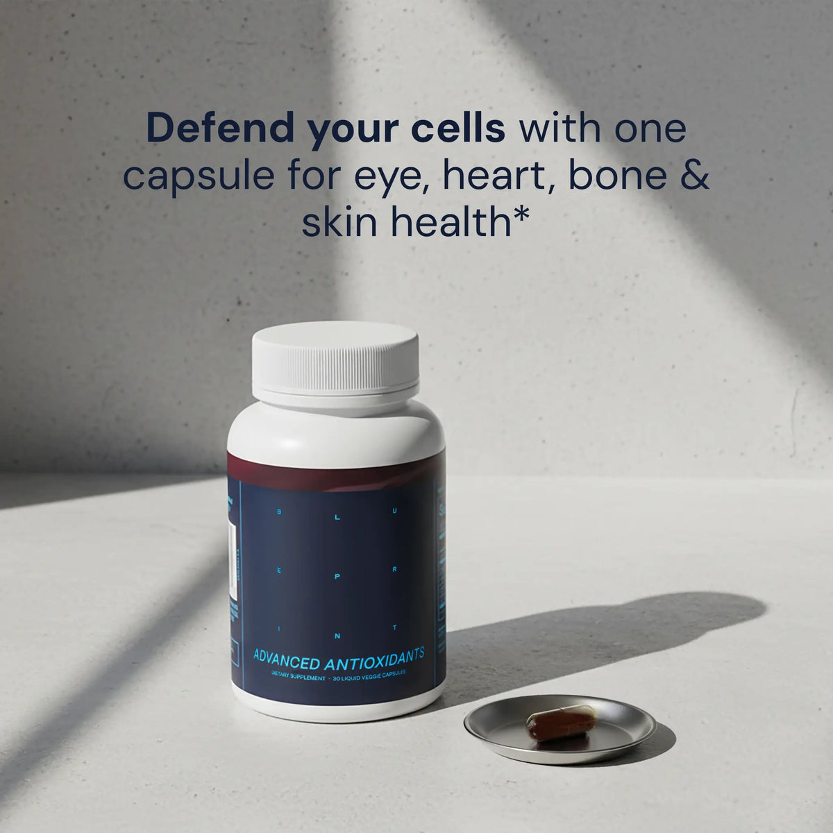 Blueprint Advanced Antioxidants supplement bottle and capsule on a stone surface — longevity cellular health support