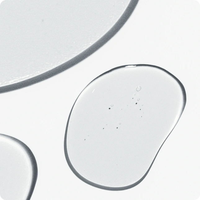 Close-up of clear gel-like serum on a light gray background