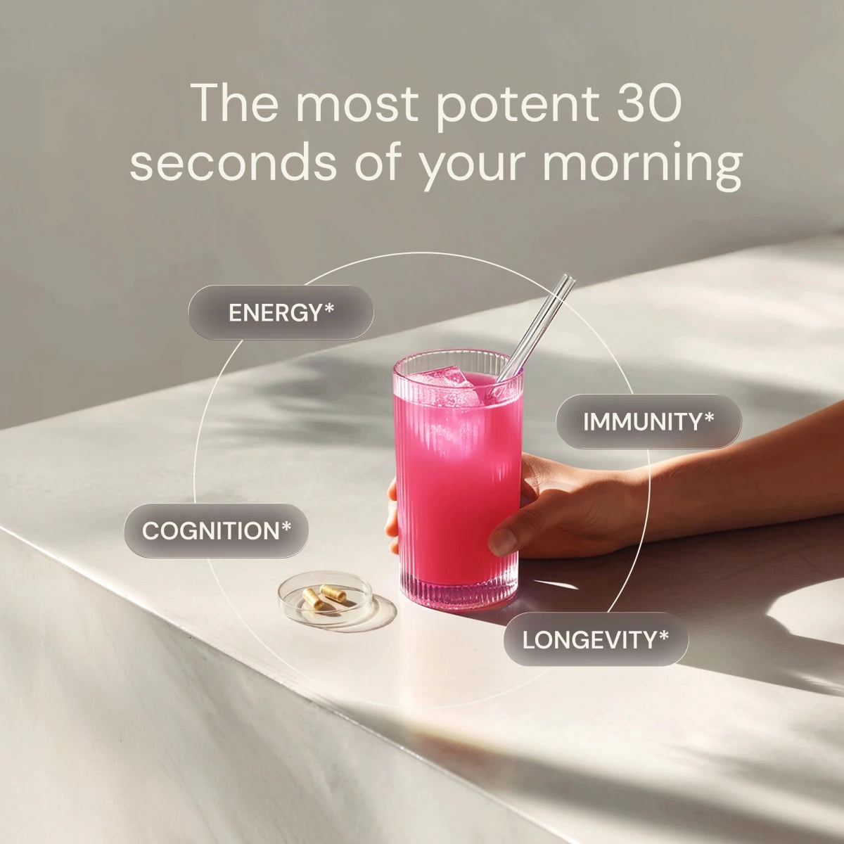 Hand holding a pink drink with health benefits text on a light surface