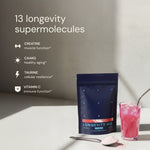 Longevity Mix powder package with a glass of pink drink on a light surface.