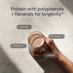 Hand holding a glass of protein shake with health benefits text on a light background