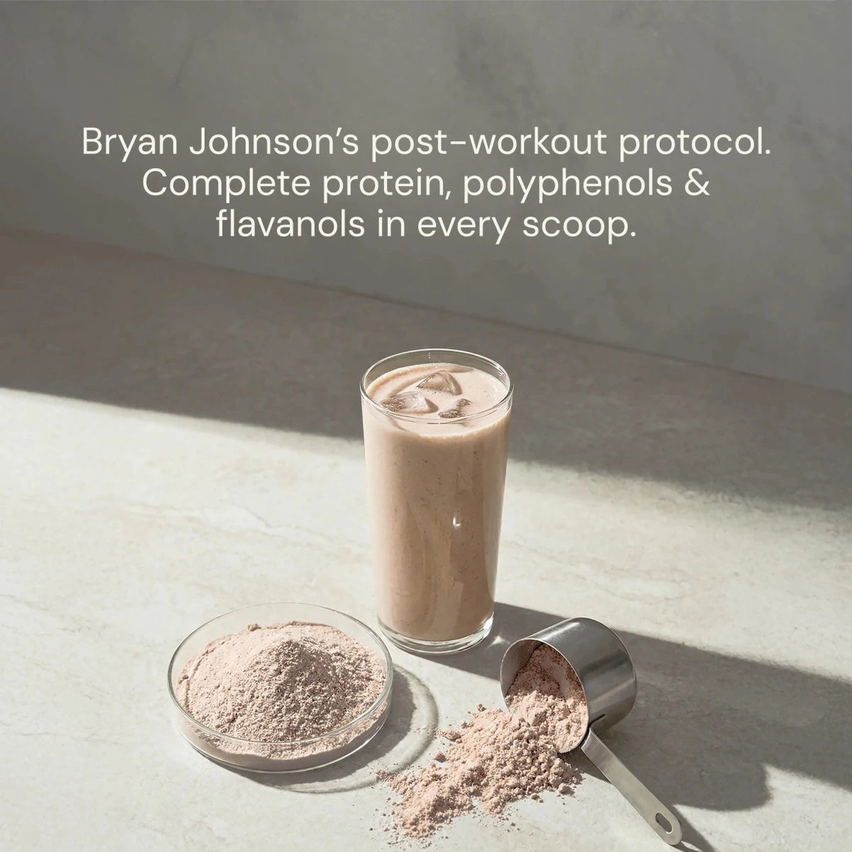 Glass of protein shake with a scoop and container on a light surface, text about Bryan Johnson's post-workout protocol.