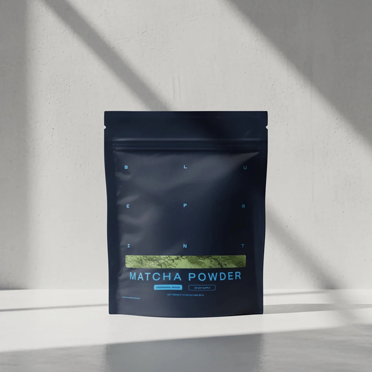 Dark blue package of matcha powder on a light gray background