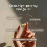 Hand holding a supplement capsule with text highlighting omega-3 benefits on a neutral background