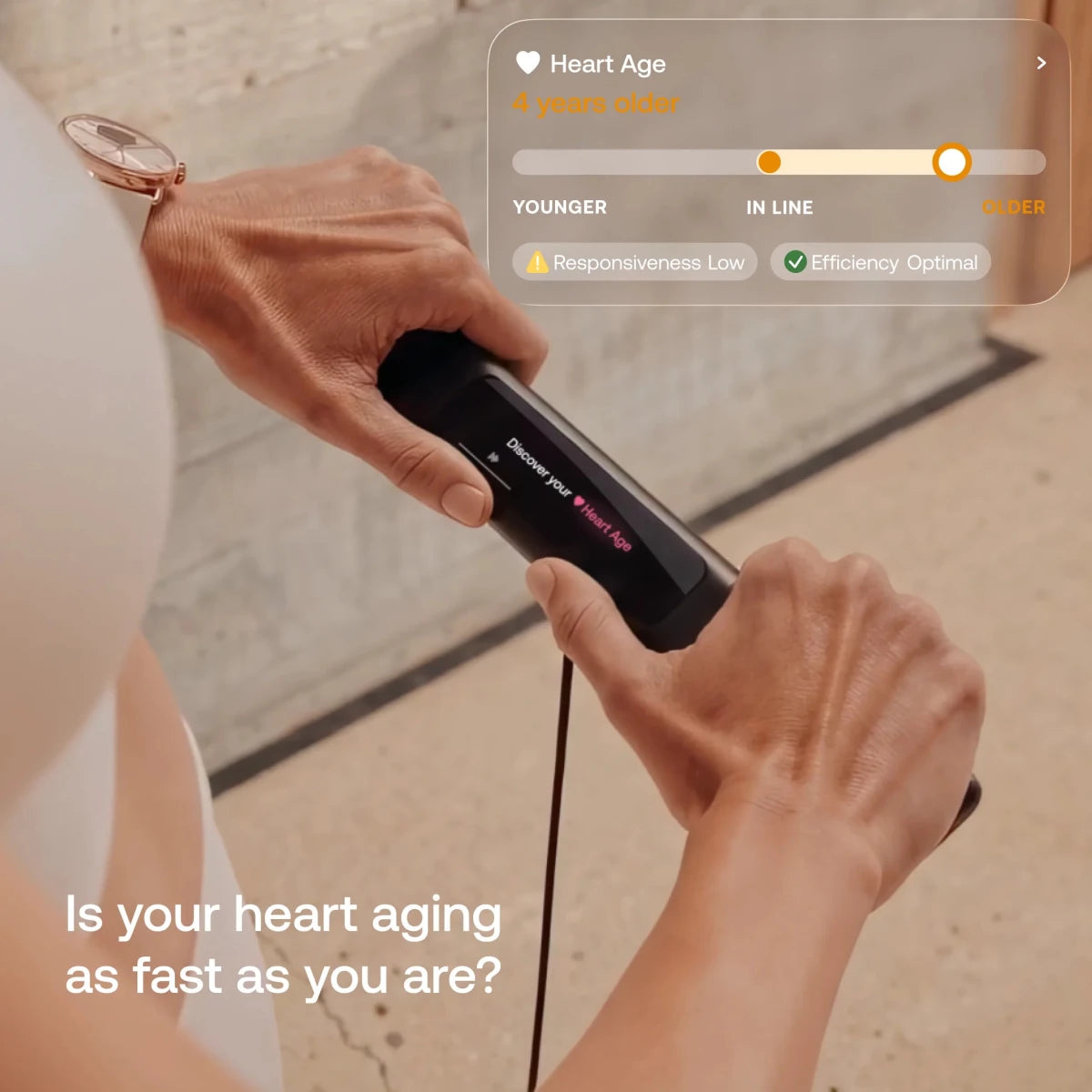 Handheld heart age monitor scanning a wrist, showing a Blueprint heart age result on screen