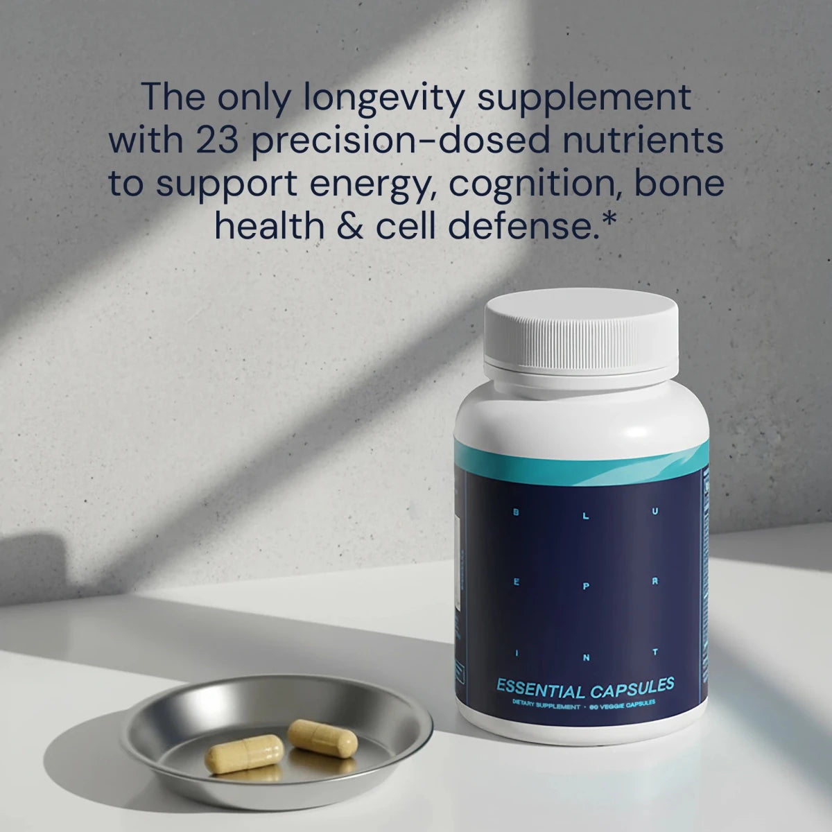 Supplement bottle labeled 'Essential Capsules' with two capsules on a tray against a gray background.