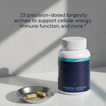Blueprint Essential Capsules bottle with two capsules in a metal dish — 23 precision-dosed longevity actives