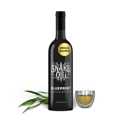 Bottle of Snake Oil Blueprint olive oil with a glass of oil on a white background