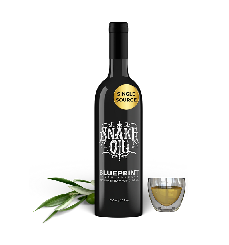 Bottle of Snake Oil Blueprint olive oil with a glass of oil on a white background