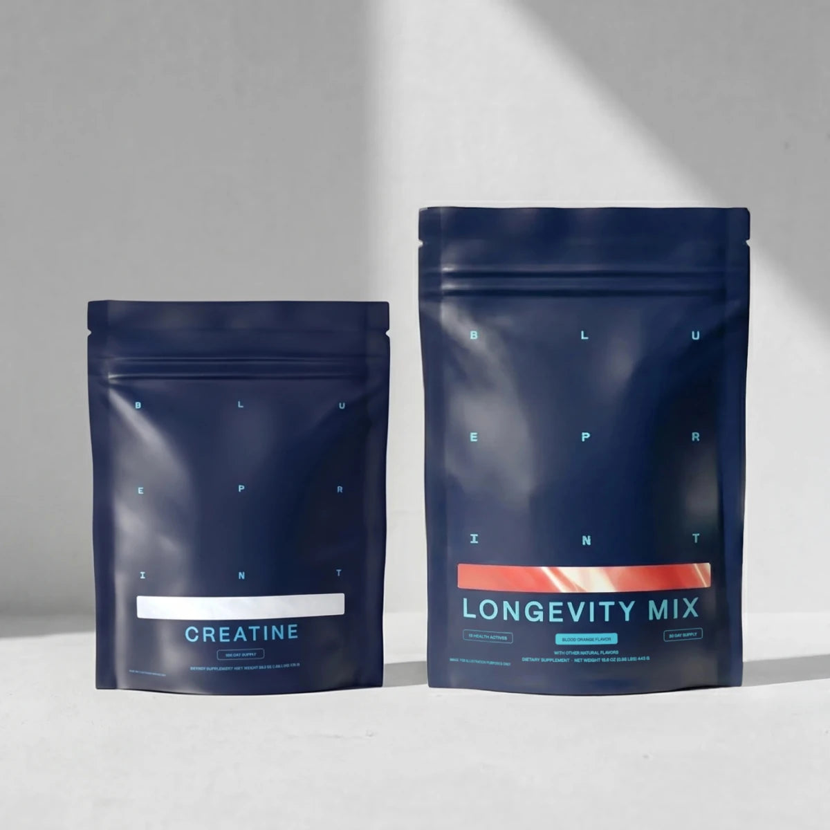 Two blue packages labeled 'Creatine' and 'Longevity Mix' on a gray background
