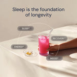 Glass of pink drink on a bed with text about sleep being the foundation of longevity.