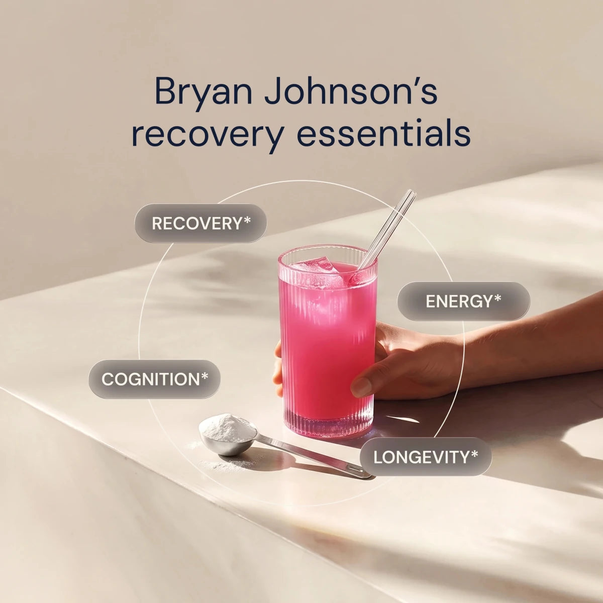 Glass of pink drink with a straw, surrounded by text on recovery, energy, cognition, and longevity, on a beige surface.