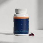 Blueprint Essential Microbiome supplement bottle with two magenta capsules on a white surface — longevity gut health