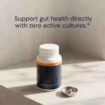 Essential Microbiome supplement bottle and capsule with gut-health headline on a stone surface — Blueprint longevity