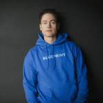 Lifestyle image of man wearing blue 'BLUEPRINT' Hoodie