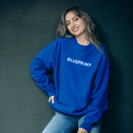 Lifestyle image of girl wearing BLUEPRINT  blue crewneck sweatshirt 