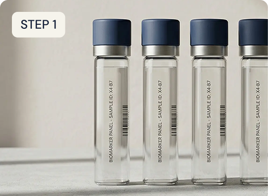 Set of four transparent bottles with blue caps on a white surface