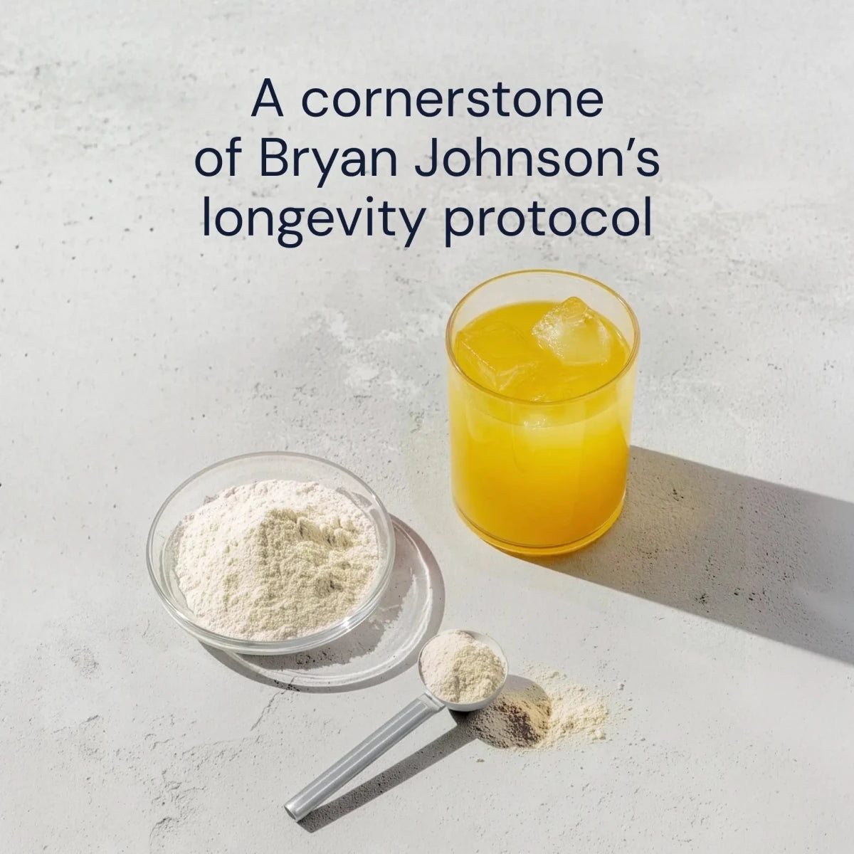 Scoop of Longevity Mix powder beside a yellow citrus drink, a cornerstone of Bryan Johnson's longevity protocol
