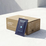 Longevity Protein package with a blue sachet in front of a cardboard box on a light background