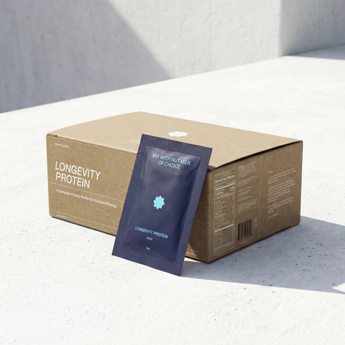 Longevity Protein package with a blue sachet in front of a cardboard box on a light background