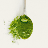 Spoonful of green matcha powder on a white background