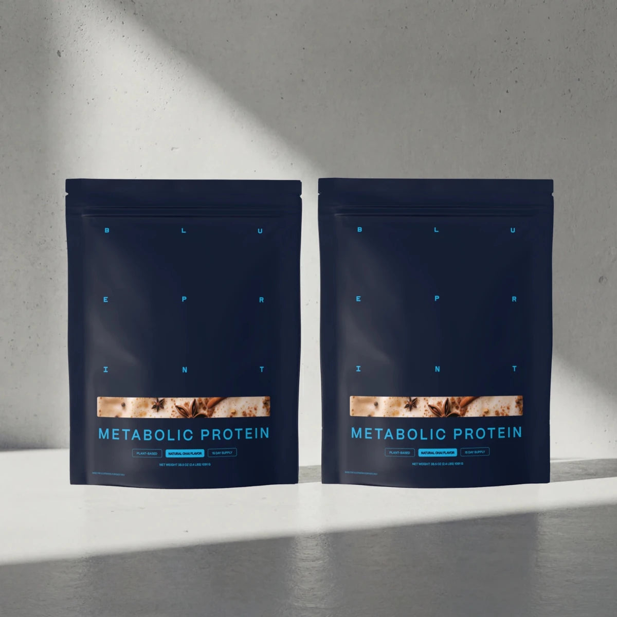 Two packages of Metabolic Protein on a gray surface with a neutral background 