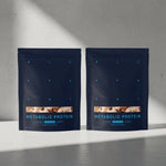 Two packages of Metabolic Protein on a gray surface with a neutral background 