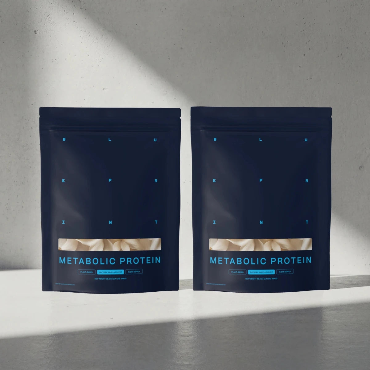 Two packages of Metabolic Protein on a gray surface with a light gray background 