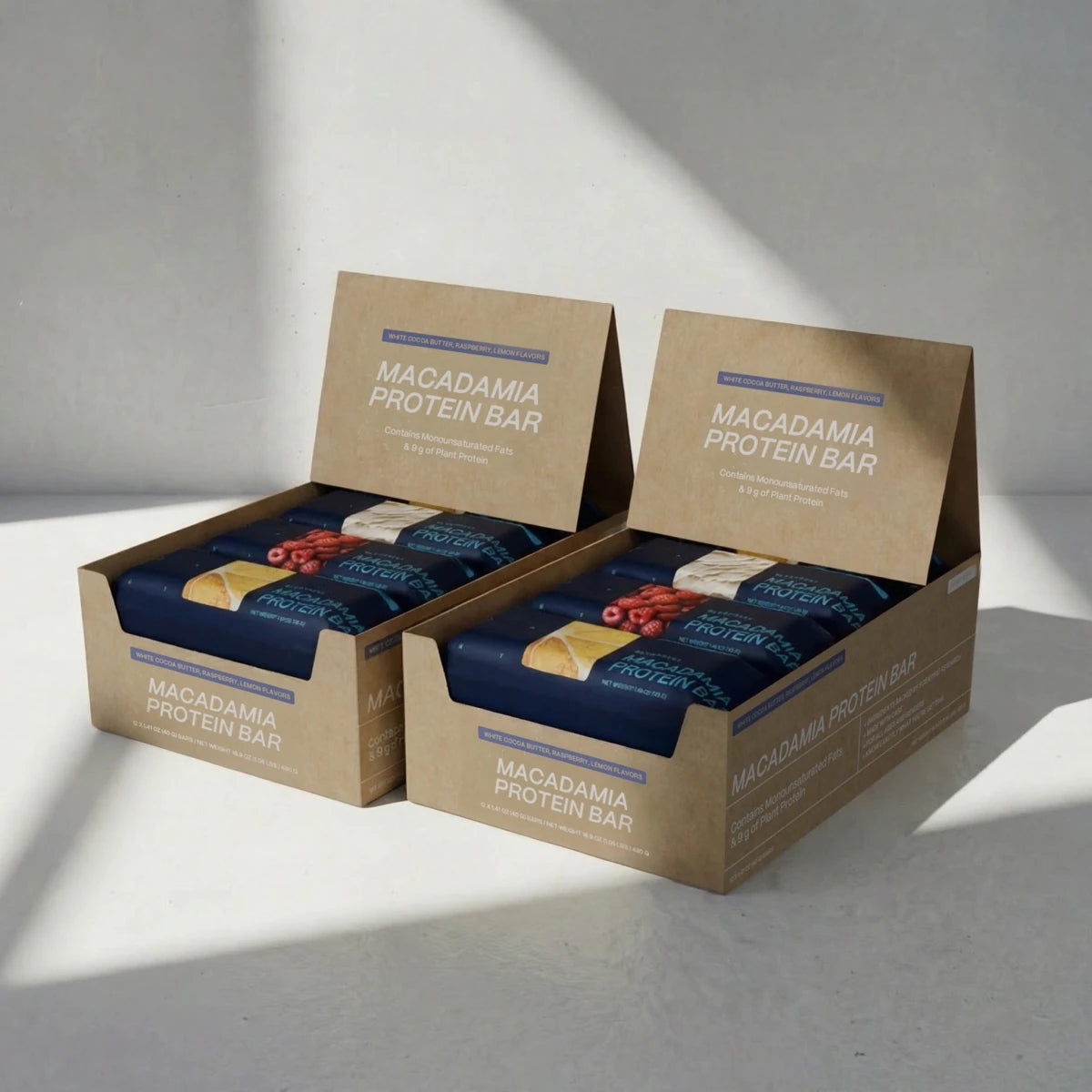 Two boxes of Macadamia Protein Bars on a light gray background