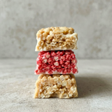 Stack of three rice krispie treats on a textured surface