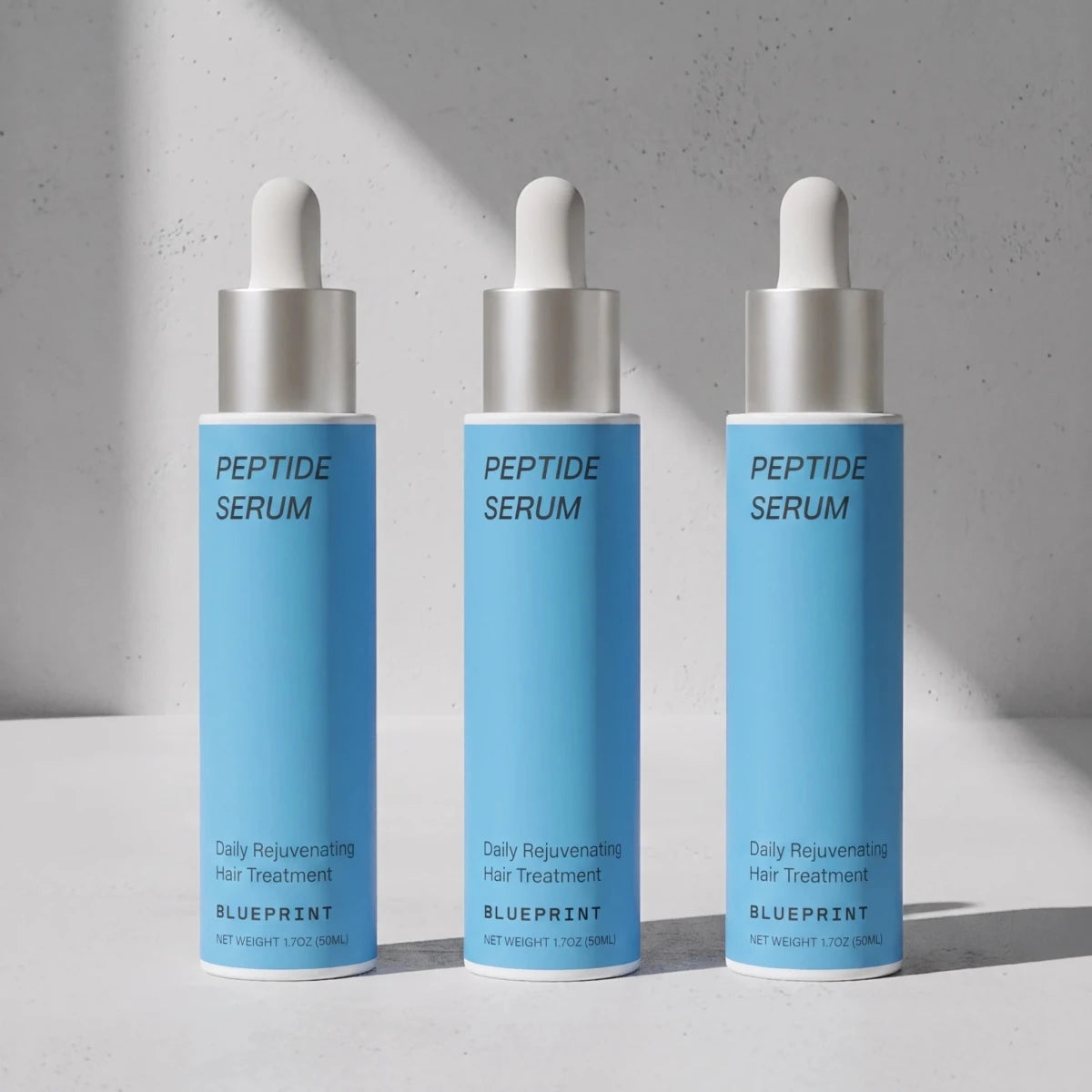 Three bottles of Blueprint Peptide Hair Serum for scalp and hair support