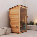 Wooden sauna with glass door in a room setting