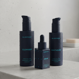 Set of skincare products including Cleanser, Serum, and Moisturizer from Blueprint on a neutral background.