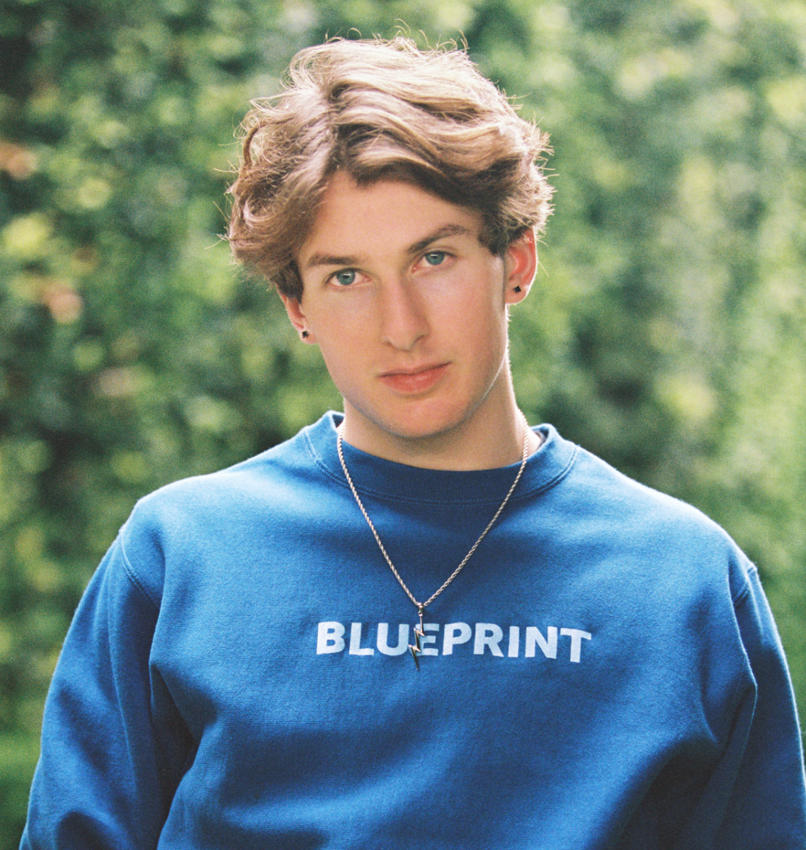 Lifestyle image of boy wearing BLUEPRINT  blue crewneck sweatshirt 